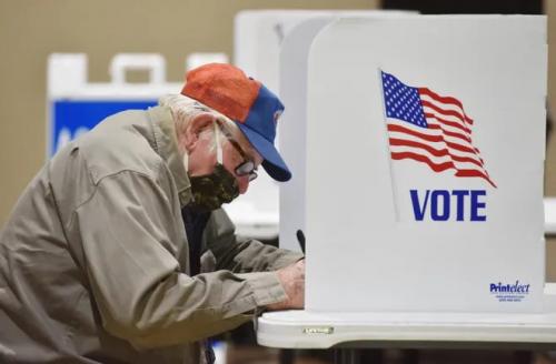 Old man with mask voting at polls