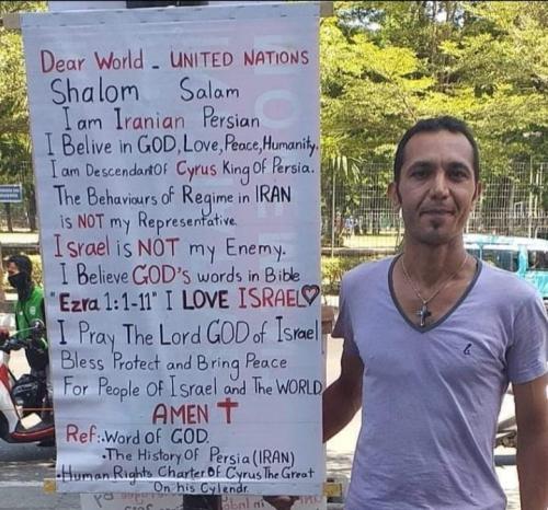 Meme Picture John Arash Sedigh.  Holding poster he made saying he stands with Israel, not Iran.