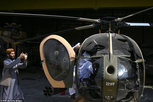 47318615-9942593-A_Taliban_fighter_takes_a_picture_of_a_damaged_MD_530_helicopter-a-66_1630434645333