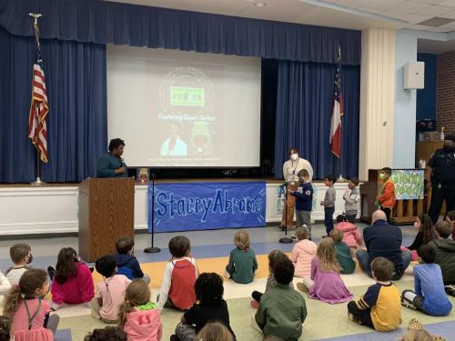 Stacey Abrams with school kids no mask at podium