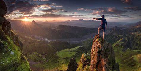 Man on top of mountain peak rock