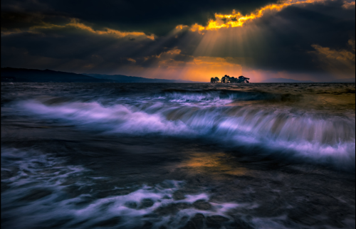 !  Beautiful Sunset through clouds on dark beach