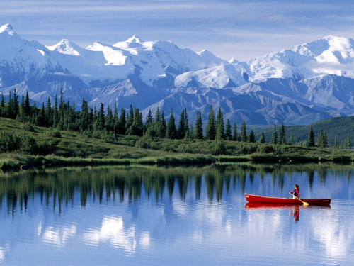 Canoeing through pristine snow melt lake