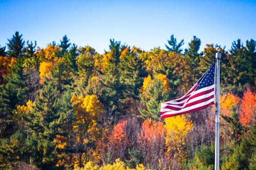 american-flag-flying-in-front-of-massachusets-fall-foliage
